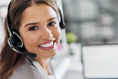 Freundlich lächelnde Supportmitarbeiterin mit Headset beim Online Broker Brokerpoint.