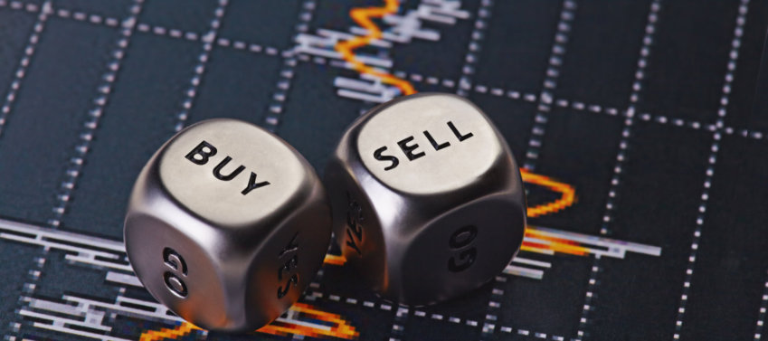 Buy-Sell Silberne Würfel vor Chart mit Aktienwerten.